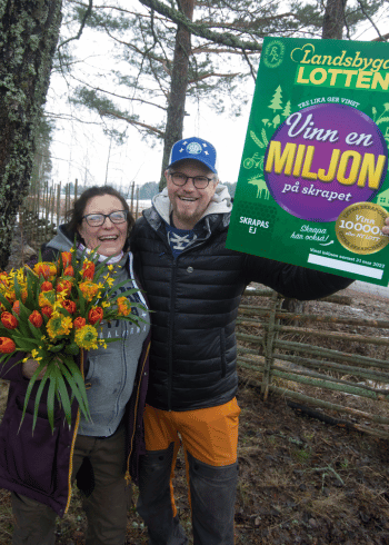Vinnarna Mia och Roger håller i blommor och Landsbygdslott